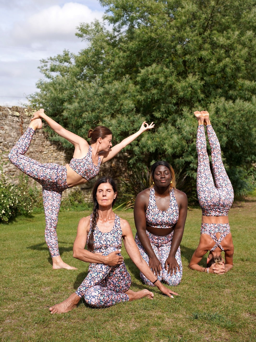 Gruppe von Frauen im Freien, die das Fitness-Leggings ‘Colibri’ mit Blumenmotiv tragen und Yoga machen