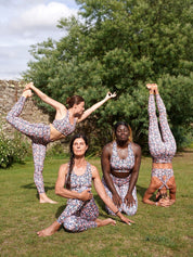 Gruppe von Frauen im Freien, die das Fitness-Leggings ‘Colibri’ mit Blumenmotiv tragen und Yoga machen