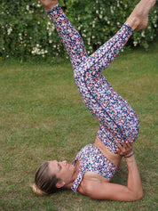 Dynamische Yoga-Pose im Freien – Frau trägt Fitness-Leggings ‘Colibri’ mit Blumenmotiv aus recyceltem Stoff