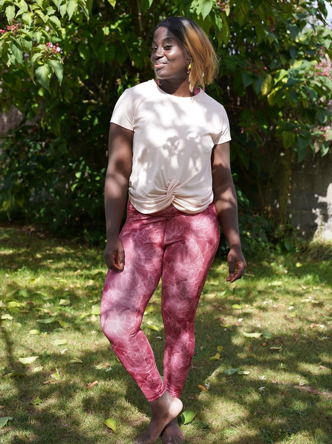 Frau im Freien trägt Bordeaux Colibri-Leggings mit Blumenmotiv, ideal für Yoga und Fitness