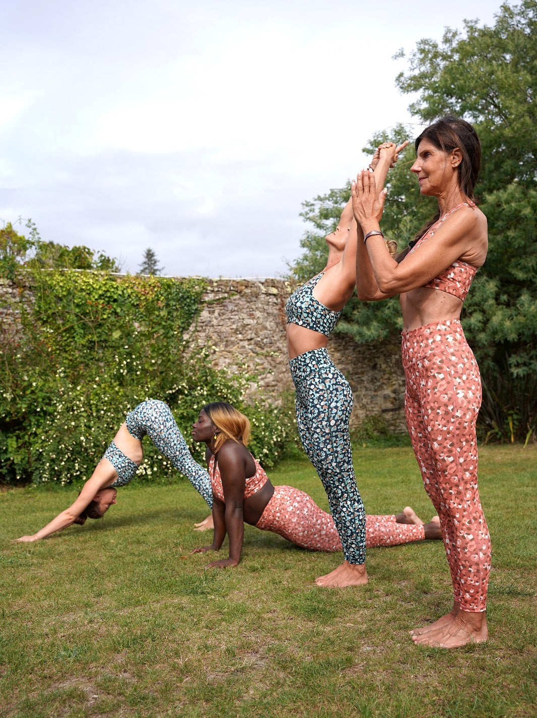 Vier Frauen beim Yoga im Freien, tragen die Colibri-Leggings mit rosa und grünen Panther-Motiven