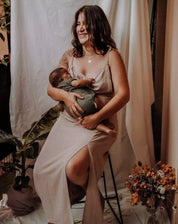 Mutter stillt ihr Baby im langen Stillkleid Noémie in Beige mit verstecktem Reißverschluss.