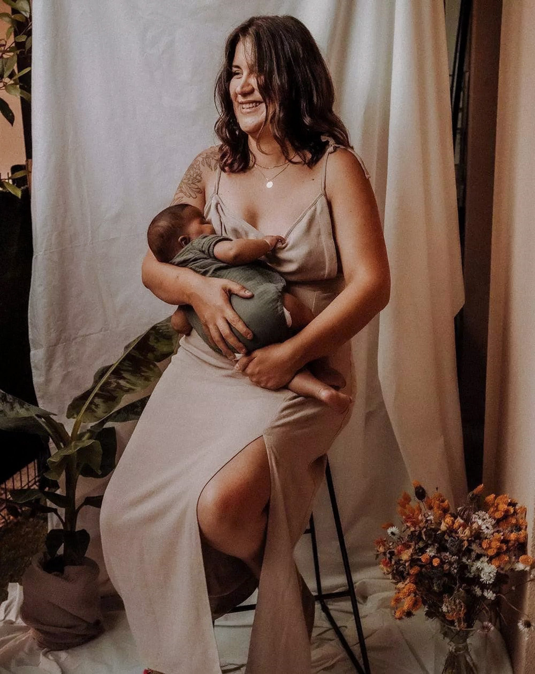 Mutter stillt ihr Baby im langen Stillkleid Noémie in Beige mit verstecktem Reißverschluss.