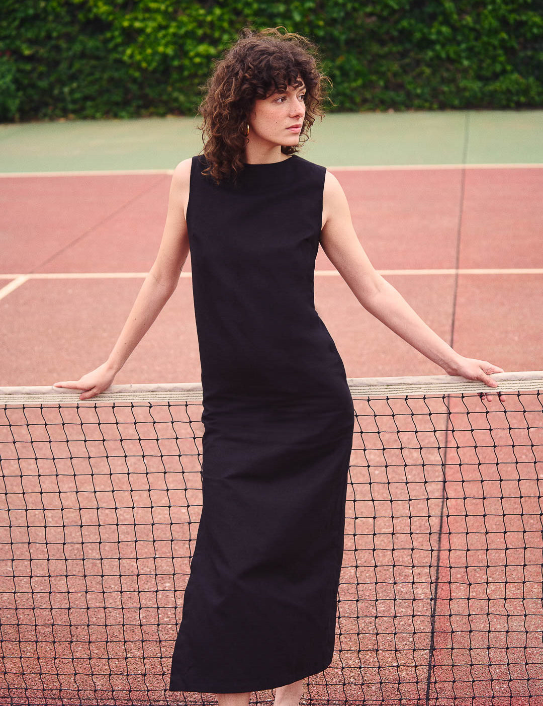 Frau trägt ein langes schwarzes Kleid aus Baumwoll-Leinen-Mix im Freien. Nachhaltige Mode aus Frankreich, elegant und zeitlos.