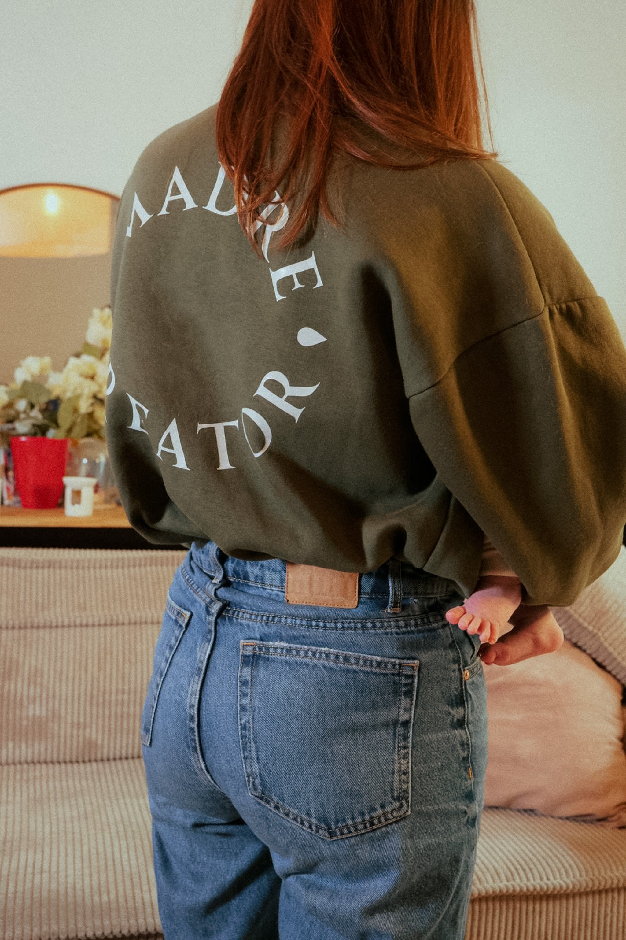 Frau trägt das khakifarbene Oversize-Still-Sweatshirt Gigi für einen modernen und lässigen Look.