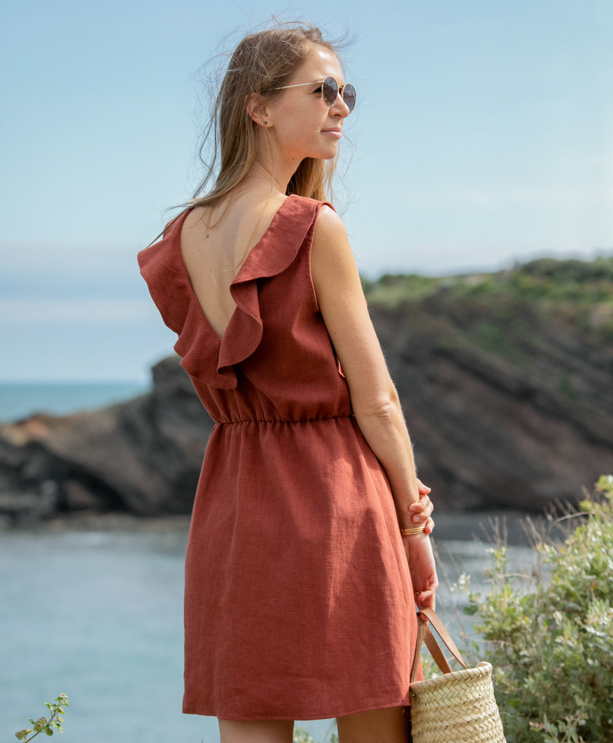 Frau trägt das Leinenkleid "Mathilde" in Terrakotta von vorne. Nachhaltiges Sommerkleid für Damen aus 100 % Leinen – in warmem Terrakotta, elegant und luftig.
