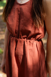 Detailaufnahme Leinenstoff Kleid Mathilde. Hochwertiger Leinenstoff in Terrakotta – atmungsaktiv, natürlich und leicht. Nachhaltige Damenmode mit französischem Savoir-faire für den Sommer.