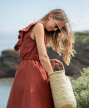 Detailansicht des Stoffs vom Sommerkleid "Mathilde" am Strand.
Naturbelassene Leinenstruktur in warmem Terrakotta – atmungsaktives, hochwertiges Material für nachhaltige Sommermode.