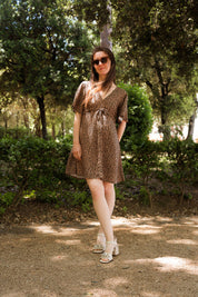Frau im Sommerkleid mit Leo-Print, elegant im Park, Blick auf das Kleid und die feminine Silhouette