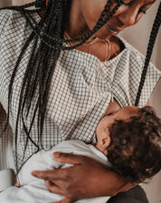 Nahaufnahme des Stilltops mit Karomuster Léna während das Baby gestillt wird. Die diskreten Reißverschlüsse an den Seiten sind deutlich sichtbar und ermöglichen ein bequemes und diskretes Stillen.