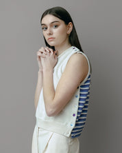 Top Cassiopée aus Merinowolle mit modulierbarem Design, Vorderteil in Ecru und Rückenteil in Blau-Violett gestreift, getragen von einer Frau