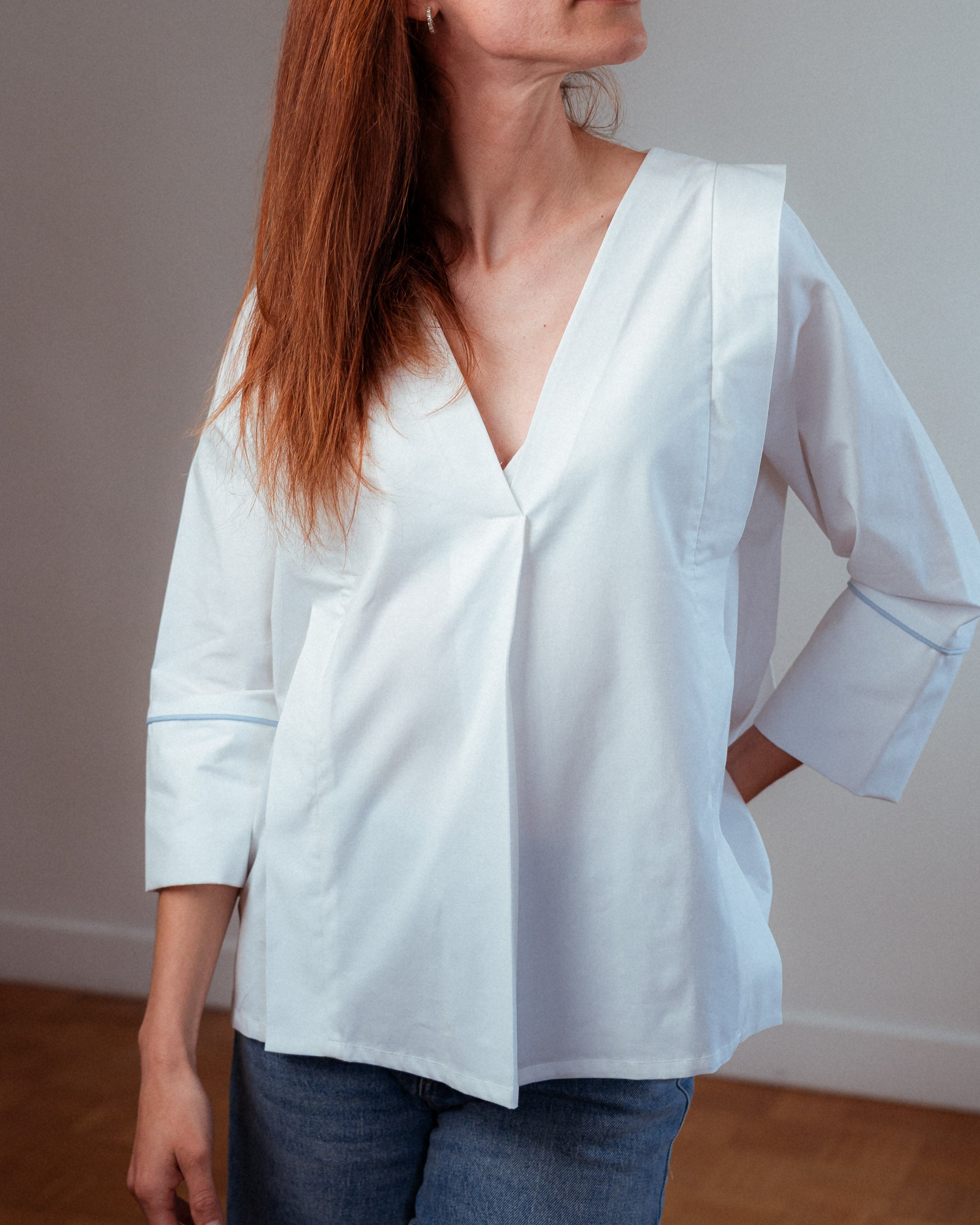 Frau trägt die weiße Stillbluse Camille  – zeitloses Design trifft auf funktionale Eleganz.