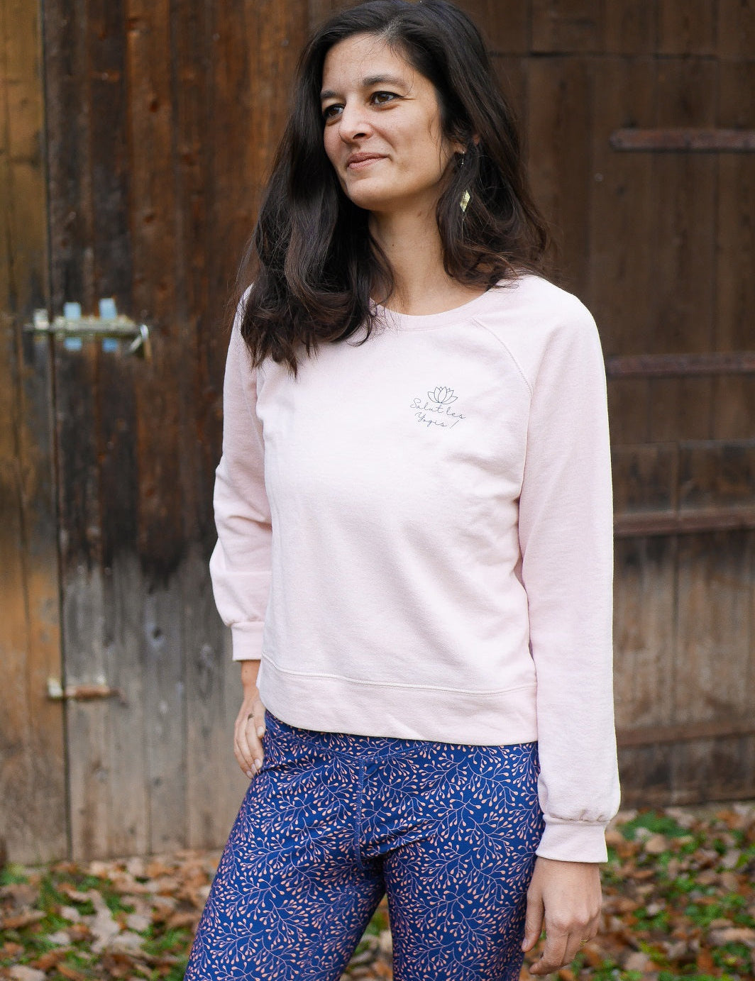 Frau trägt das 'Héron' Sweatshirt in Rosa beim Training im Freien – perfekt für Yoga oder entspannte Momente in der Natur.