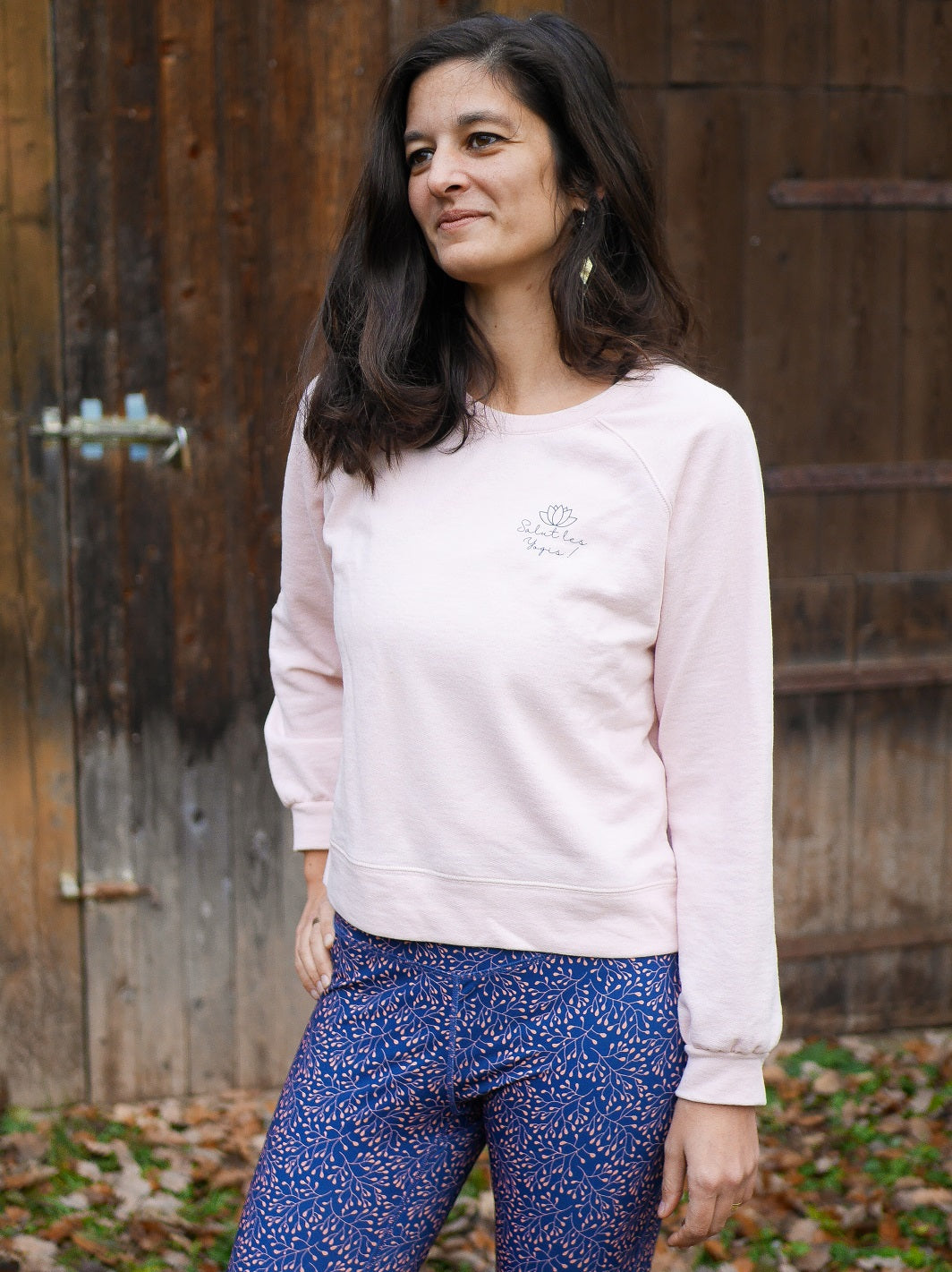 Frau trägt das 'Héron' Sweatshirt in Rosa beim Training im Freien – perfekt für Yoga oder entspannte Momente in der Natur.