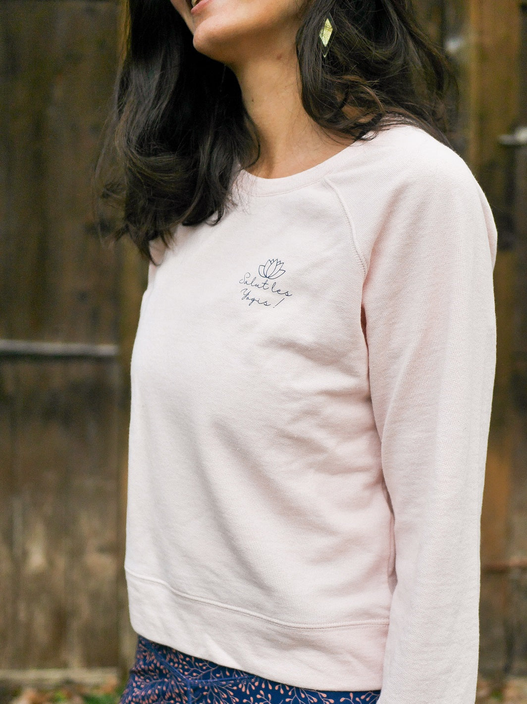 Frau entspannt sich im Freien und trägt das 'Héron' Sweatshirt in Rosa – ideal für Sport und Erholung.