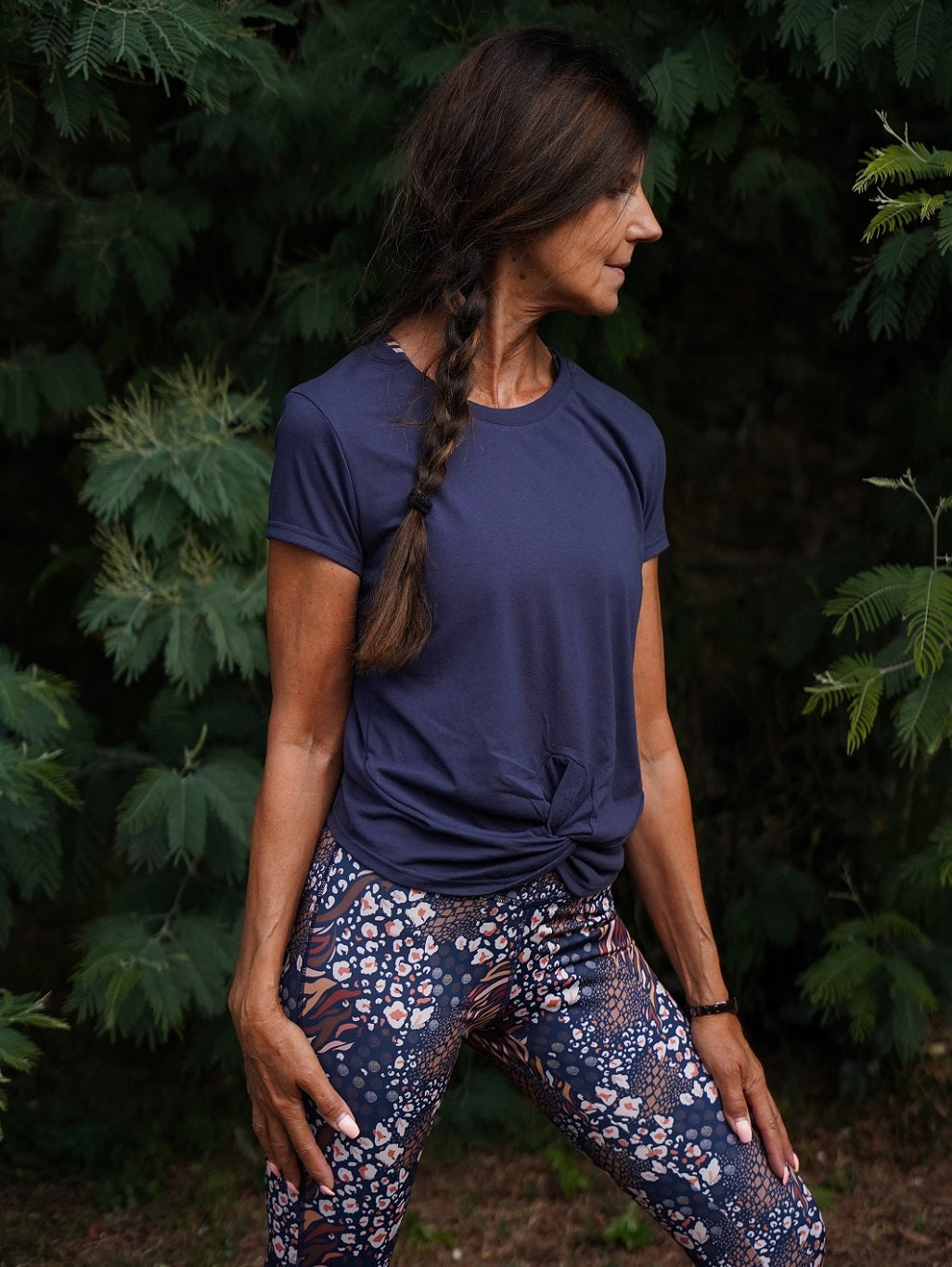 Frau in sportlichem Yoga-T-Shirt „Toucan“ – marineblaue Variante aus recyceltem Material, perfekt für Bewegung & Komfort