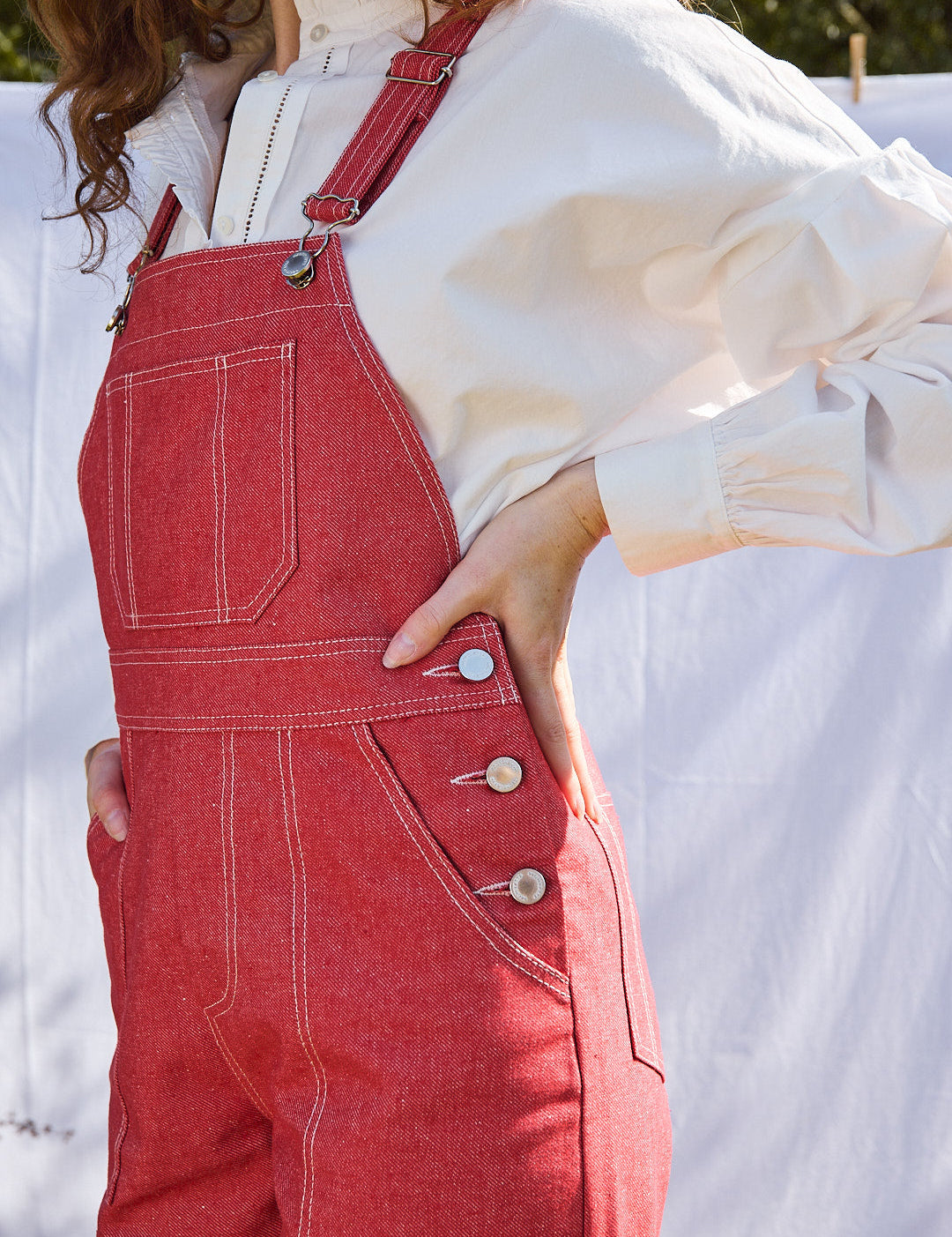 Nahaufnahme des roten Denimstoffs der Flared-Latzhose, draußen