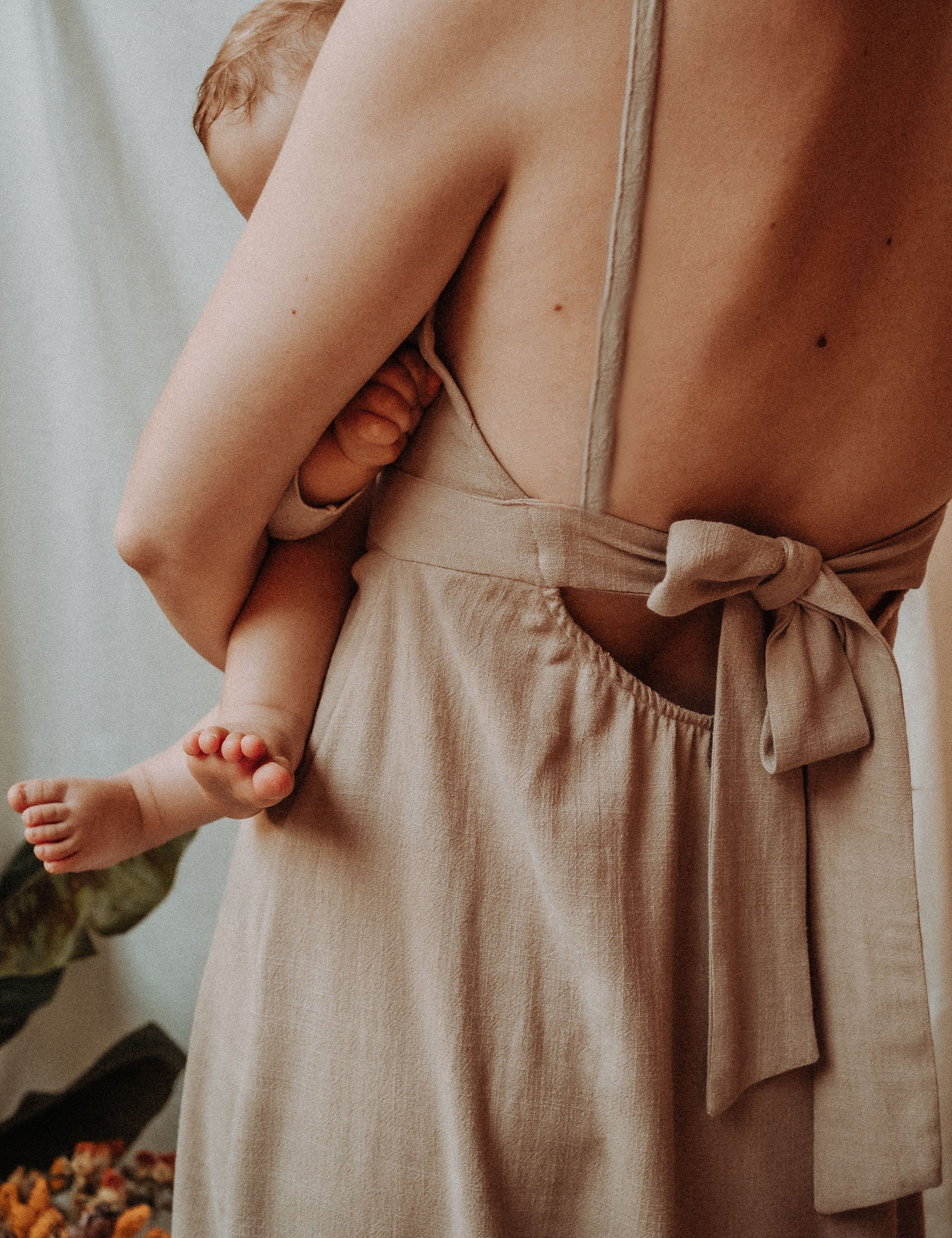 Studioaufnahme des Stillkleids Noémie von hinten – betont der tiefe Rückenausschnitt und die feminine Schleife