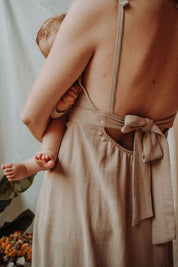 Studioaufnahme des Stillkleids Noémie von hinten – betont der tiefe Rückenausschnitt und die feminine Schleife