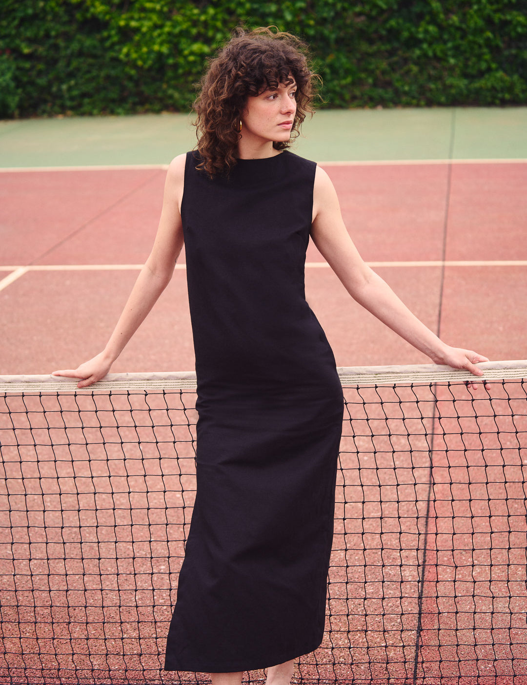 Frau trägt ein langes schwarzes Kleid aus Baumwoll-Leinen-Mix im Freien. Nachhaltige Mode aus Frankreich, elegant und zeitlos.