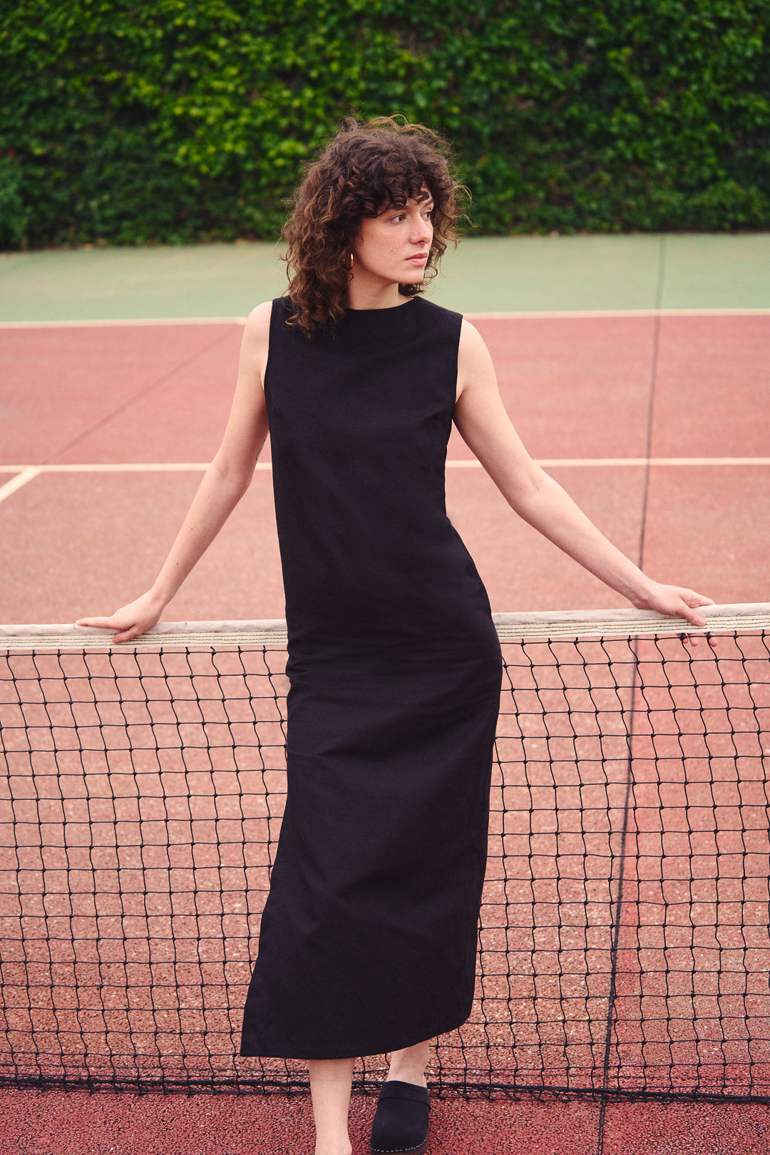 Frau trägt ein langes schwarzes Kleid aus Baumwoll-Leinen-Mix im Freien. Nachhaltige Mode aus Frankreich, elegant und zeitlos.