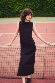 Frau trägt ein langes schwarzes Kleid aus Baumwoll-Leinen-Mix im Freien. Nachhaltige Mode aus Frankreich, elegant und zeitlos.