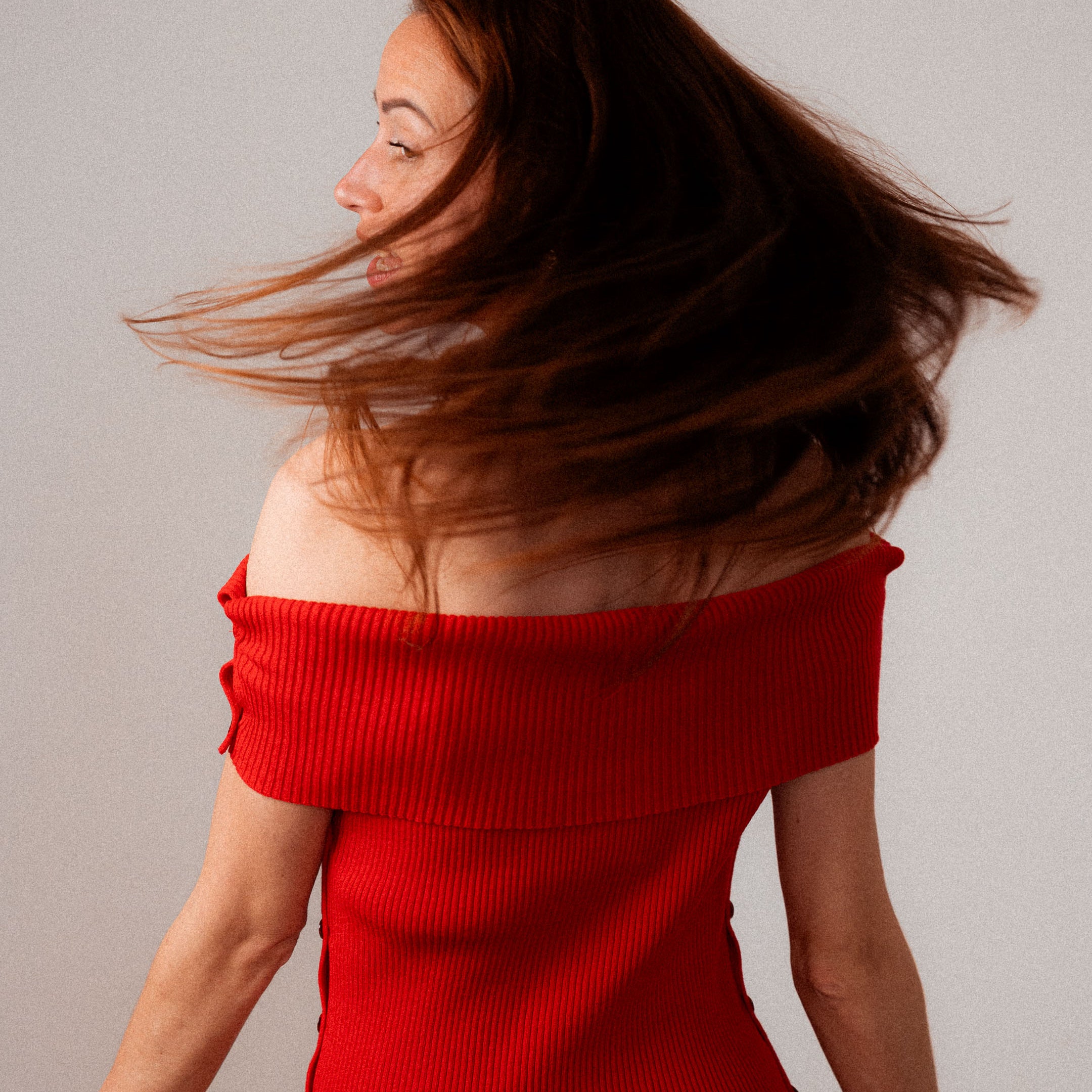 Rotes Strickkleid Céphée mit Bardot-Ausschnitt, figurbetont geschnitten, getragen von einer Frau.