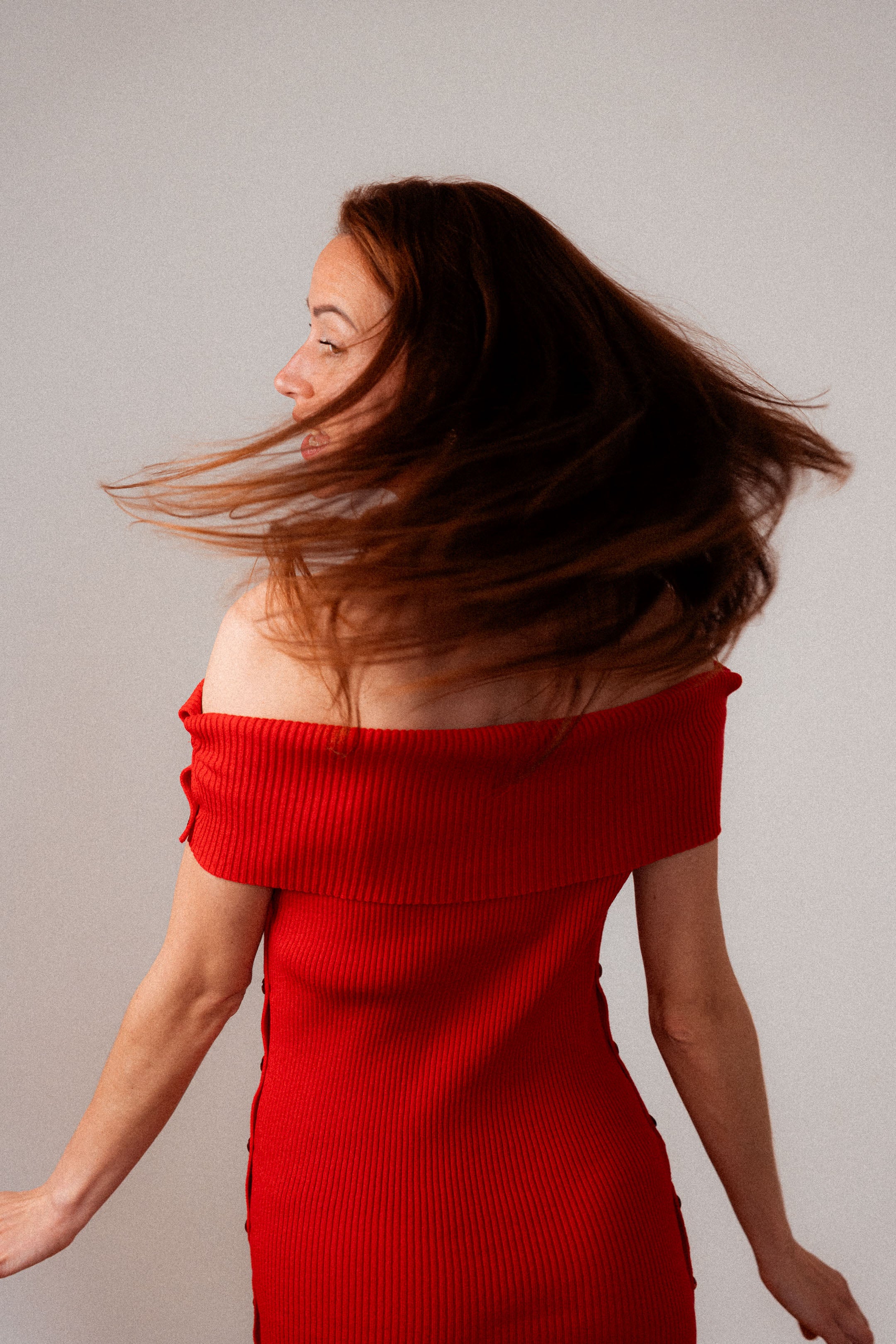 Rotes Strickkleid Céphée mit Bardot-Ausschnitt, figurbetont geschnitten, getragen von einer Frau.
