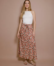Frau trägt Maxirock mit Blumenmuster aus EcoVero-Viskose, nachhaltige Damenmode aus Frankreich, luftiger Schnitt, kombiniert mit weißem Top.