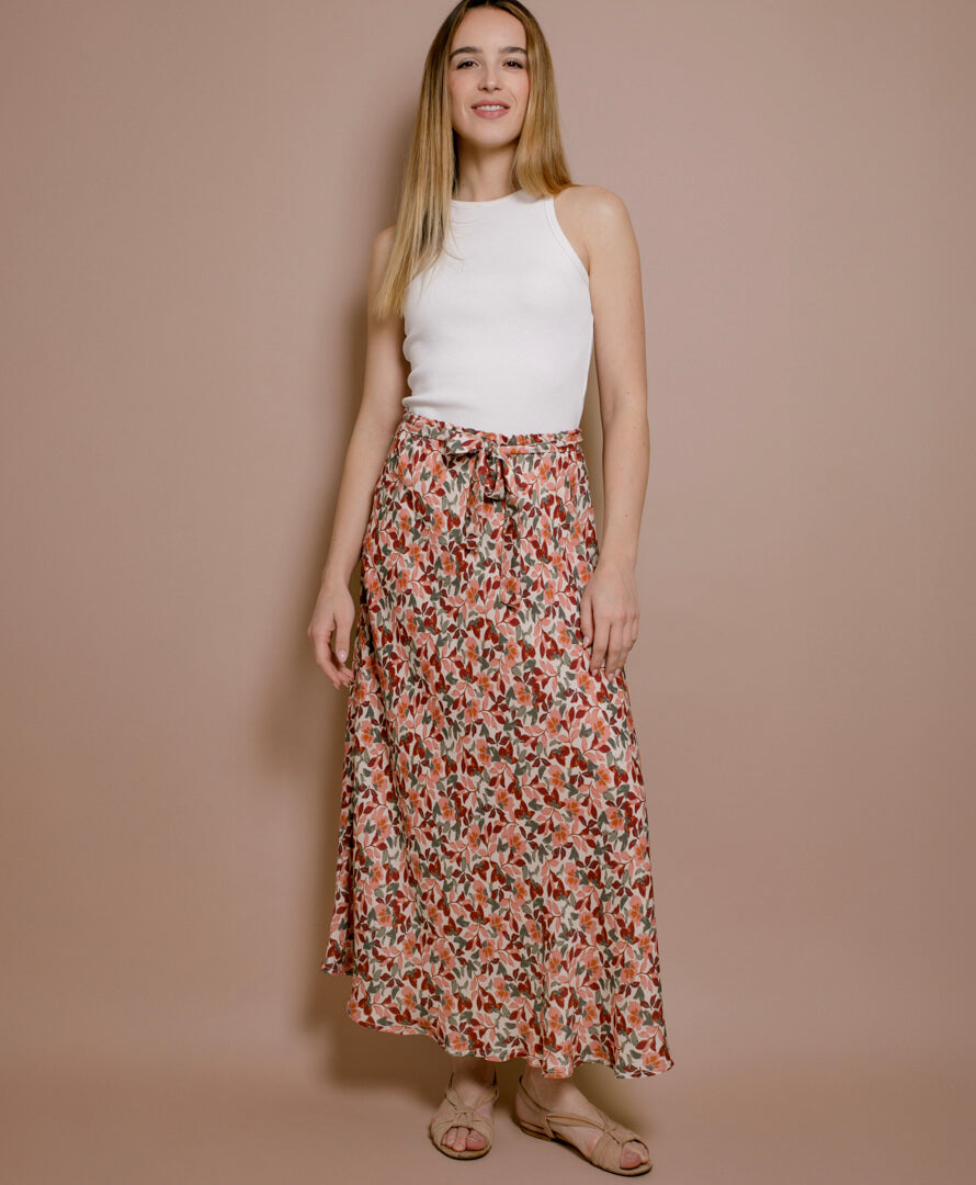 Frau trägt Maxirock mit Blumenmuster aus EcoVero-Viskose, nachhaltige Damenmode aus Frankreich, luftiger Schnitt, kombiniert mit weißem Top.