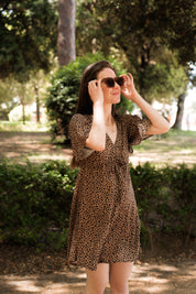 Frau steht im Grünen, Blick auf das fließende Sommerkleid und die femininen Details
Leichtes Sommerkleid mit Leo-Print aus nachhaltiger EcoVero™-Viskose.