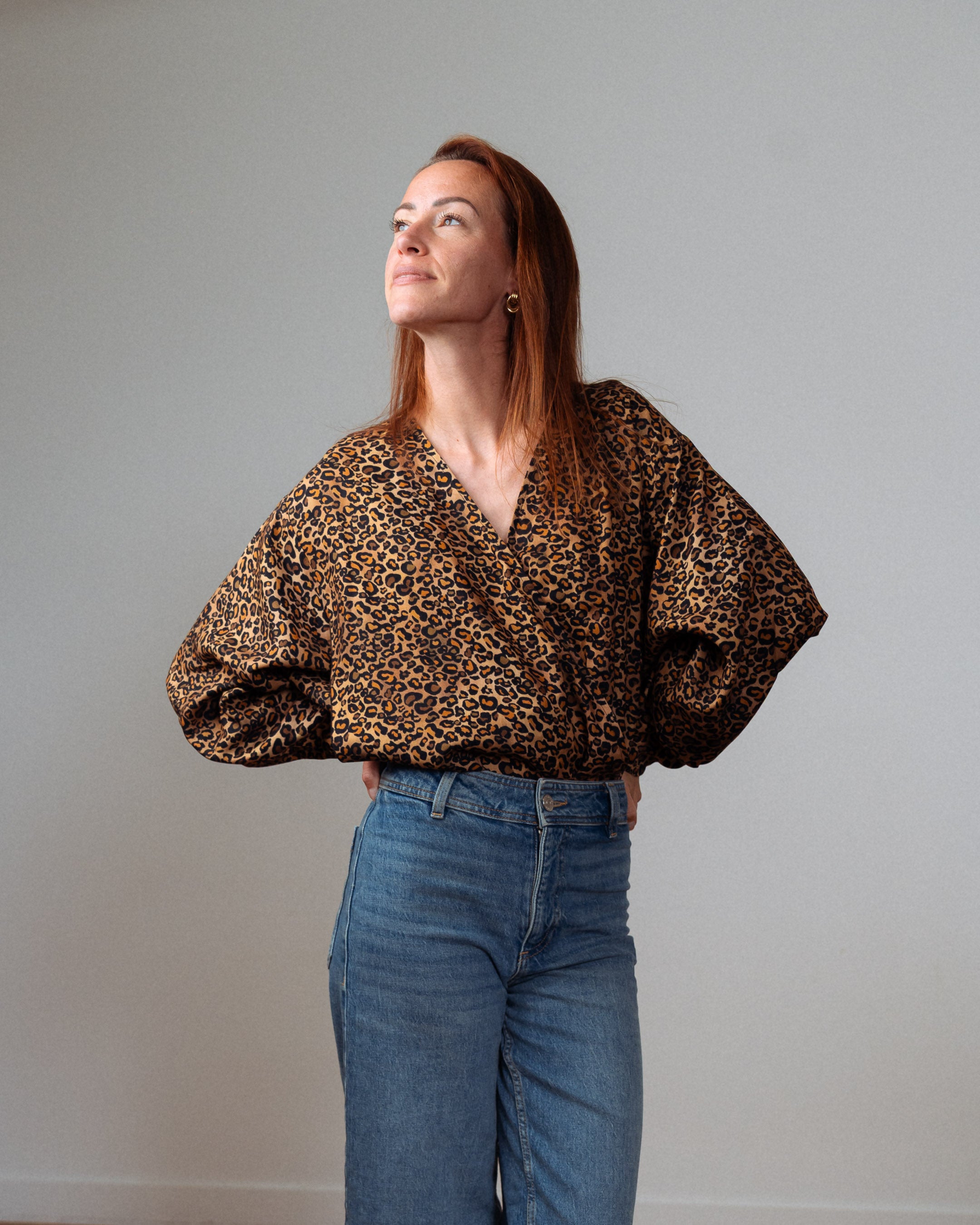 Stillbody Marion – eleganter Body mit Wickelausschnitt und Leo-Muster, in Kombination mit einem bequemen Jeanslook für einen modernen, lässigen Style.