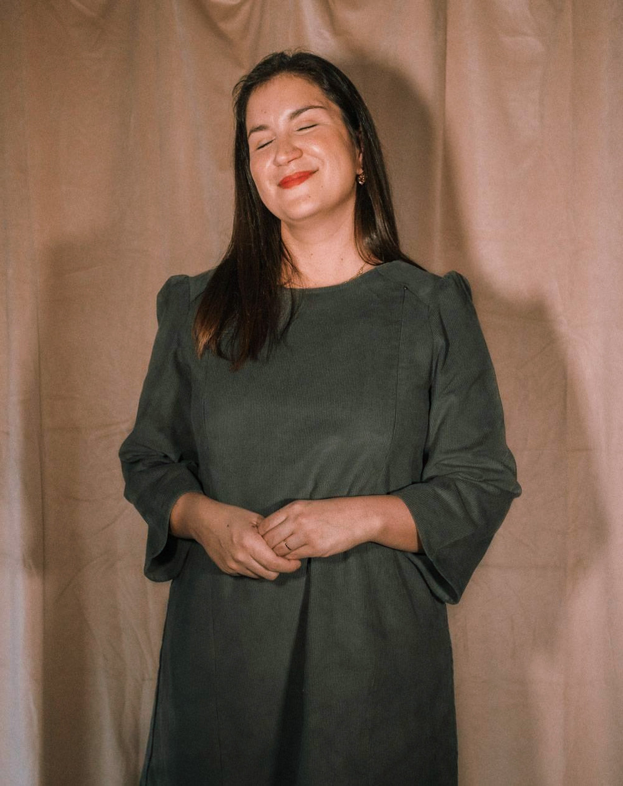Das Stillkleid Maria aus Cord in Grau-Grün, mit diskreter Stillöffnung, während des Stillens getragen.