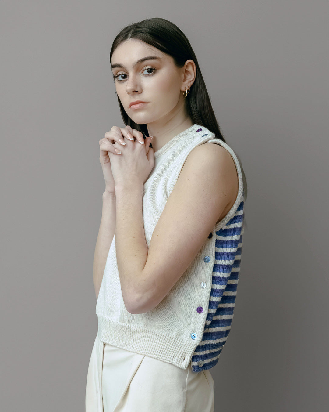 Top Cassiopée aus Merinowolle mit modulierbarem Design, Vorderteil in Ecru und Rückenteil in Blau-Violett gestreift, getragen von einer Frau 