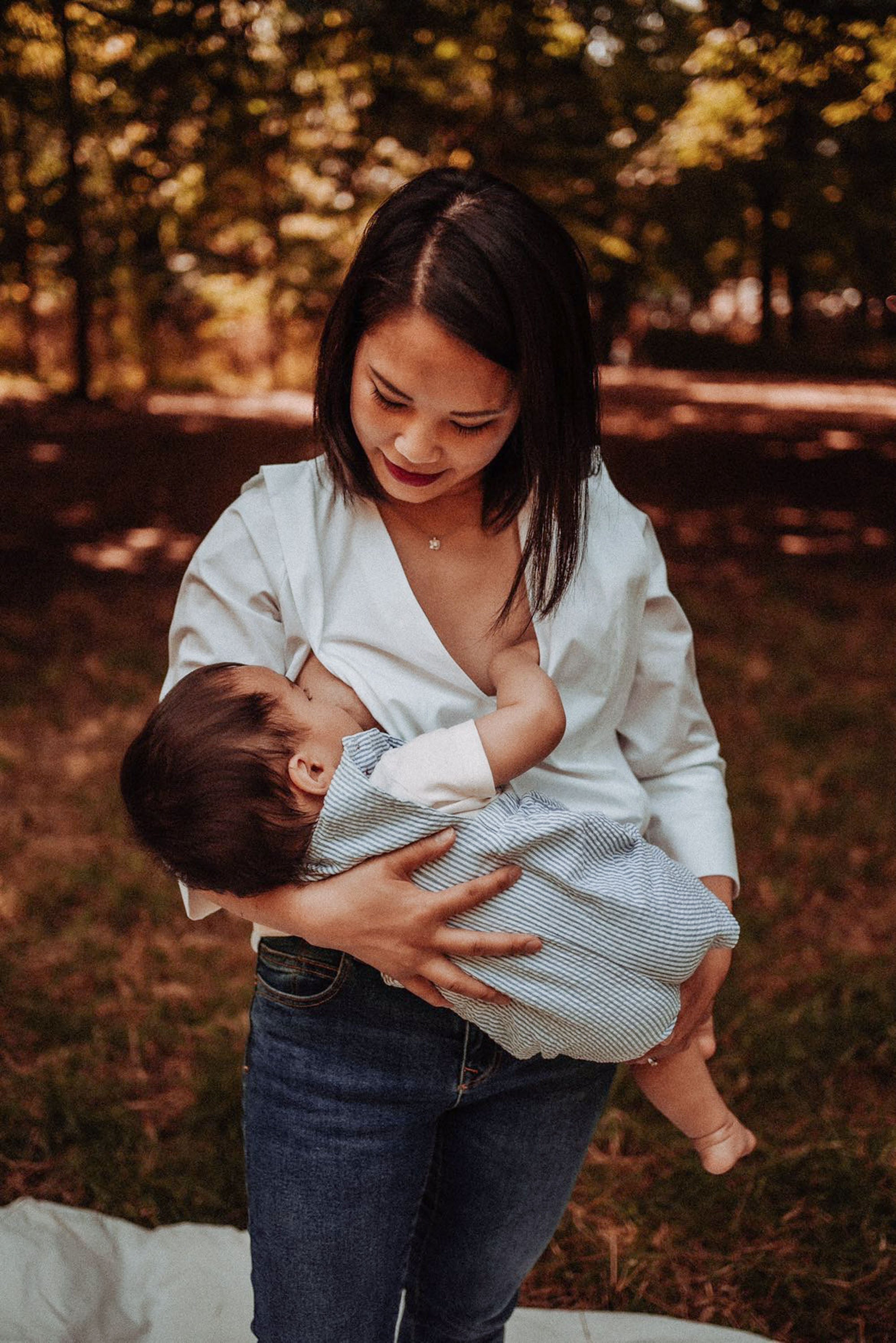 Frau stillt ihr Baby draußen in der Stillbluse Camille – diskret, stilvoll und perfekt für den Alltag.