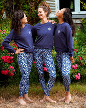Drei Frauen tragen das Sweatshirt 'Héron' in Marineblau beim Yoga im Freien – leicht, atmungsaktiv und dehnbar für maximale Bewegungsfreiheit.
