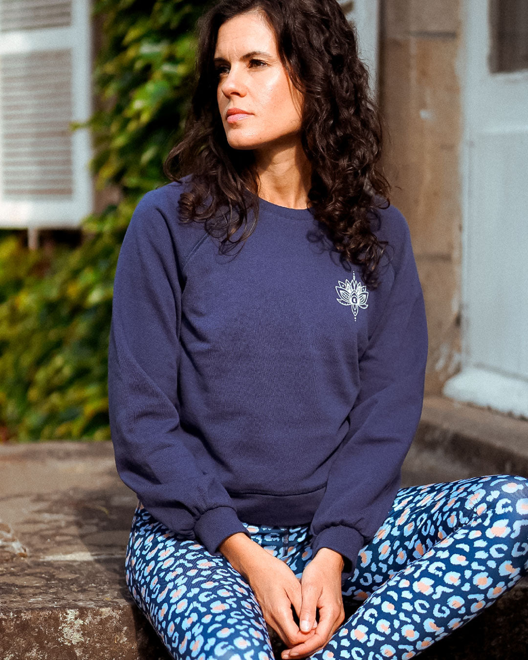 Frau trägt das Sweatshirt 'Héron' in Marineblau beim Yoga – elegantes, vielseitiges Design für Sport und Entspannung.