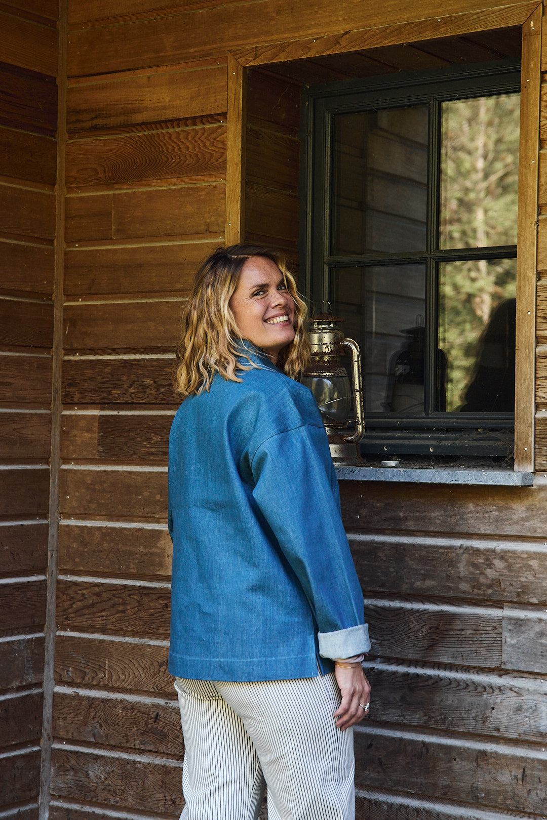 Rückansicht der Bluse im Seglerstil aus blauem Denim, getragen von Frau im Freien
