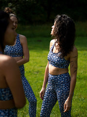 Seitenansicht von drei Frauen beim Training, trägt den Sport-Bustier Mésange und die Colibri-Leggings im Leo-Print blau, nachhaltige Sportbekleidung aus recyceltem Polyester