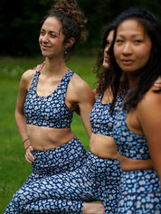 Drei Frauen tragen Sport-Bustier Mésange und Colibri-Leggings im Leo-Print blau beim Training, Yoga und Fitnessübungen, nachhaltige Sportbekleidung aus recyceltem Polyester