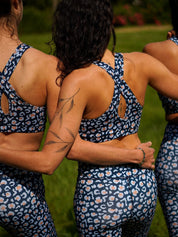 Rückansicht von drei Frauen in Sport-Bustier Mésange und Colibri-Leggings im Leo-Print blau, atmungsaktiv und bequem für Yoga und Fitnessübungen