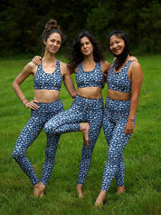 Drei Frauen tragen den Sport-Bustier Mésange und die passende Colibri-Leggings im Leo-Print blau, frontal, für Yoga und Fitness