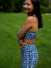 Frau trägt Sport-Bustier Mésange und Colibri-Leggings im Leo-Print blau, Seitenansicht, nachhaltige Yoga Kleidung Damen aus recyceltem Polyester
