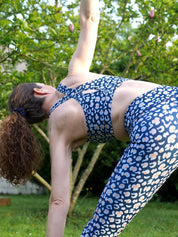 Frau trägt Sport-Bustier Mésange und Colibri-Leggings im Leo-Print blau beim Yoga, Rückansicht, nachhaltige Yoga Kleidung Damen aus recyceltem Polyester