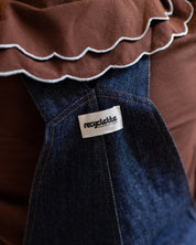 Detailaufnahme der Rückseite der dunkelblauen Denim-Latzhose