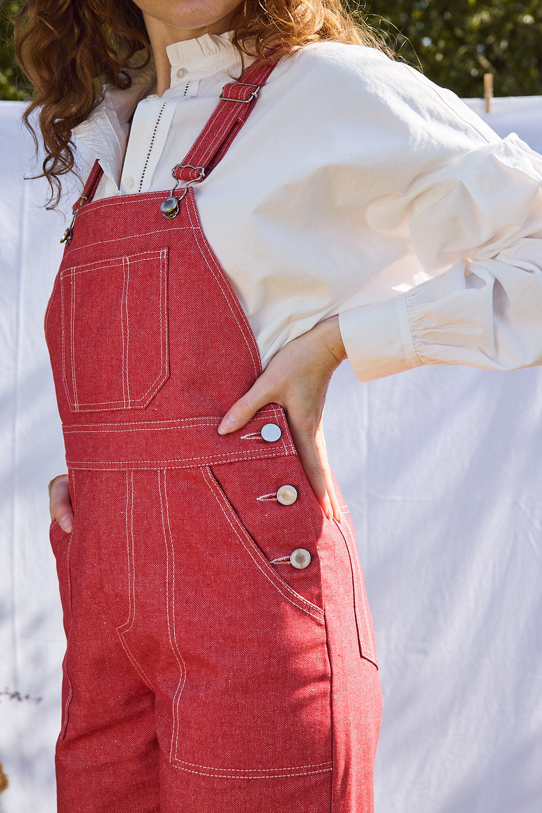 Nahaufnahme des roten Denimstoffs der Flared-Latzhose, draußen