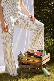 Detailaufnahme der ausgestellten Beine der Latzhose mit gestickten Blumen