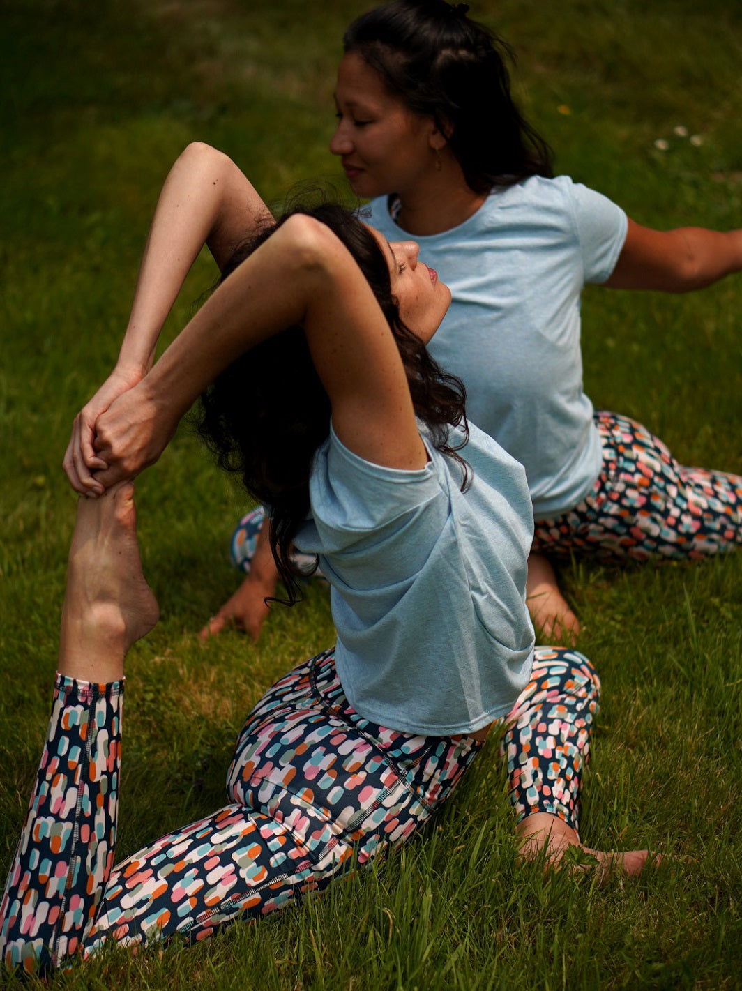 Frau in Yoga-Pose draußen im COLIBRI-Leggings mit farbenfrohem grafischem Muster – atmungsaktiv und flexibel für Trainingseinheiten aller Art.