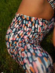 Nahaufnahme der Beine in der COLIBRI-Leggings mit buntem grafischem Muster – weiches, elastisches Material für höchsten Komfort.