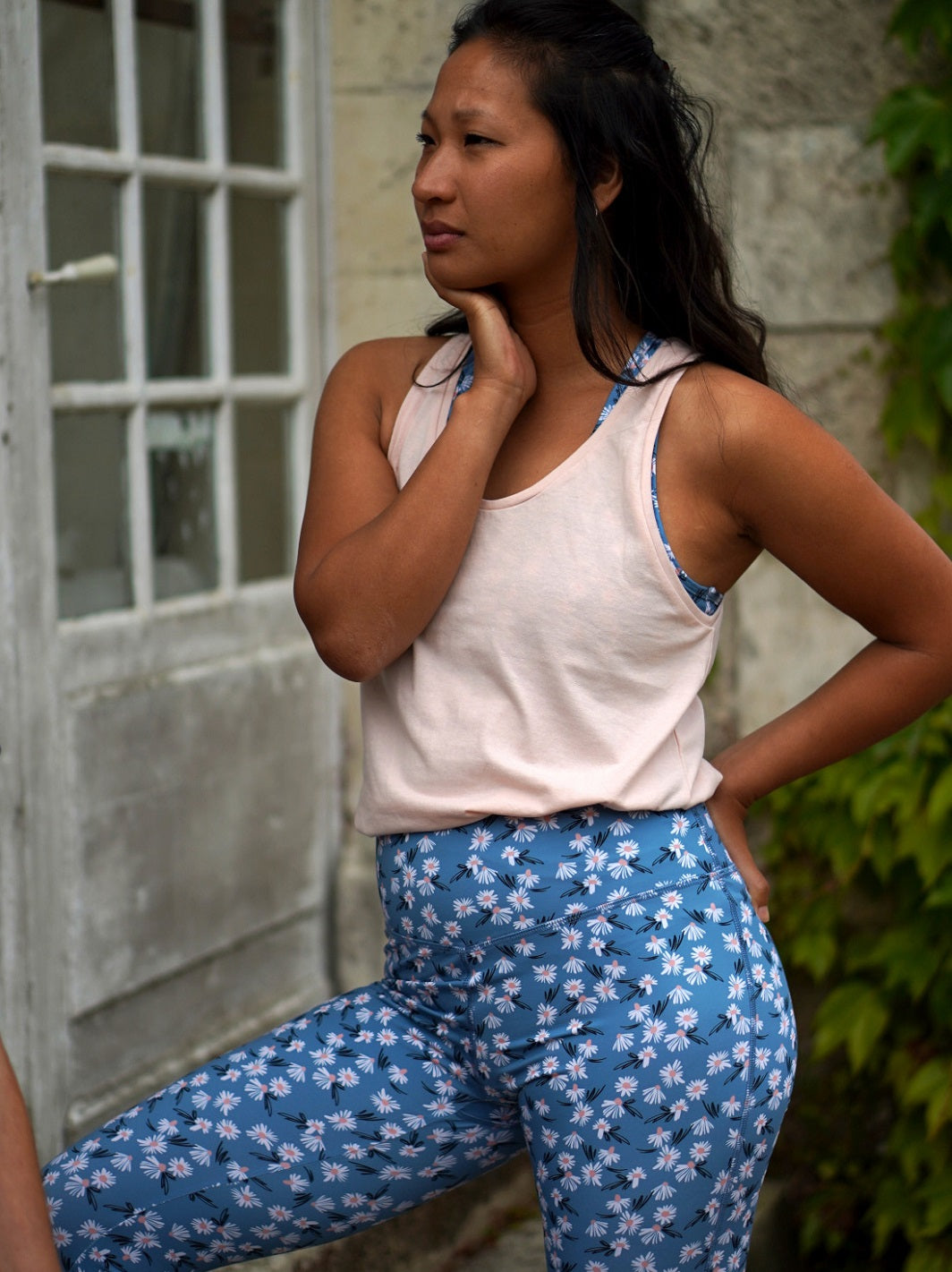 Stehende Frau im Freien trägt den COLIBRI-Leggings mit frischem Margeriten-Motiv – bequem und stylisch für den Alltag.